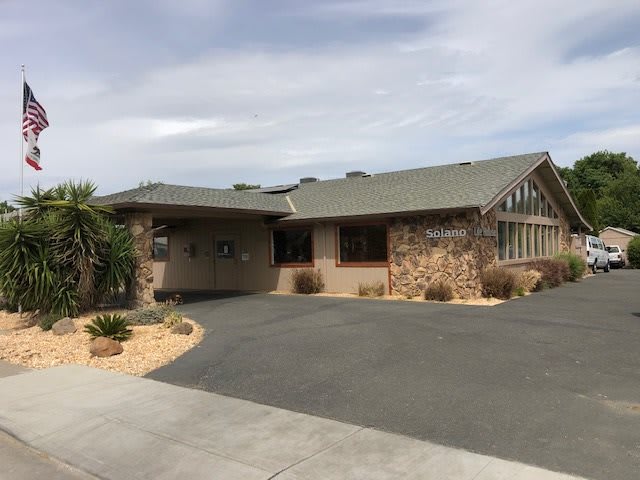 A single-story suburban house with a stone exterior and a driveway.