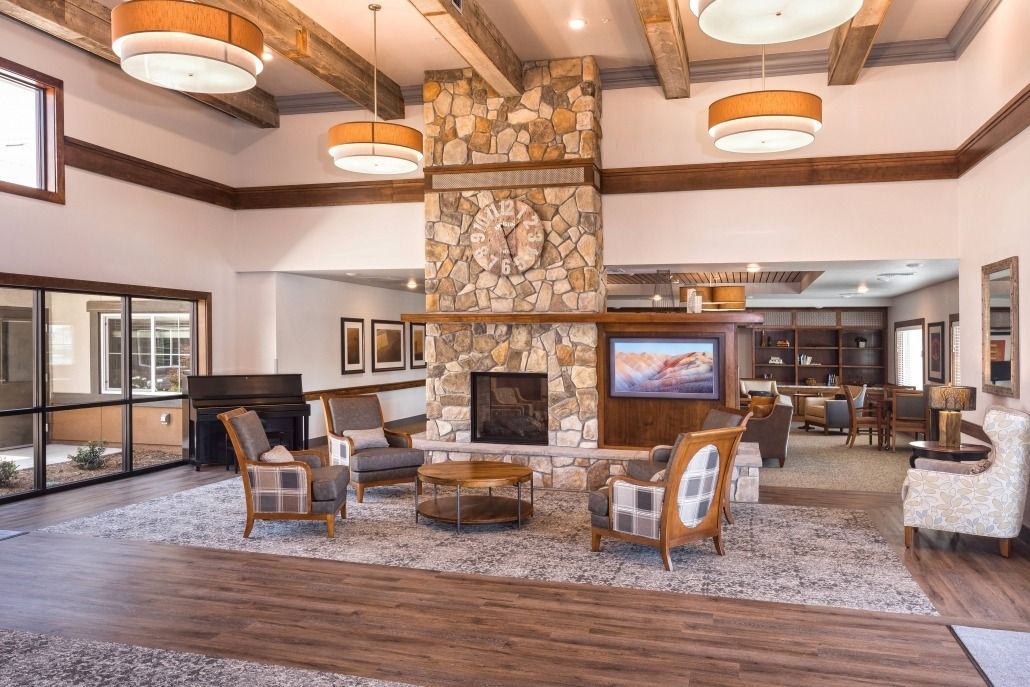 A cozy living room with a stone fireplace and rustic wooden beams.