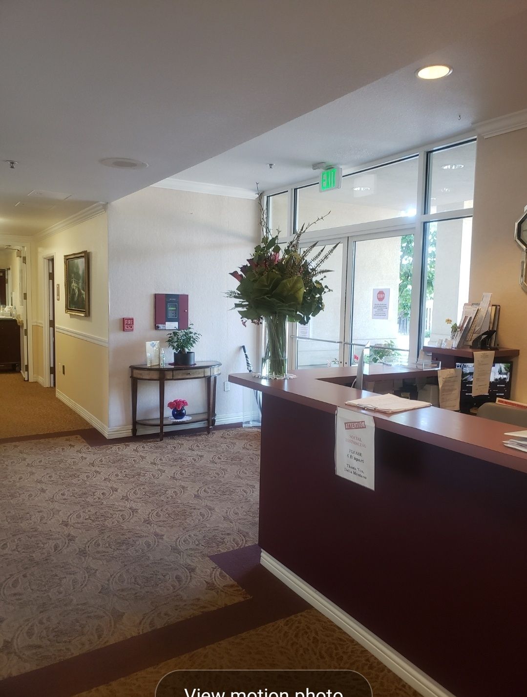 A bright reception area with a desk and hallway in the background.