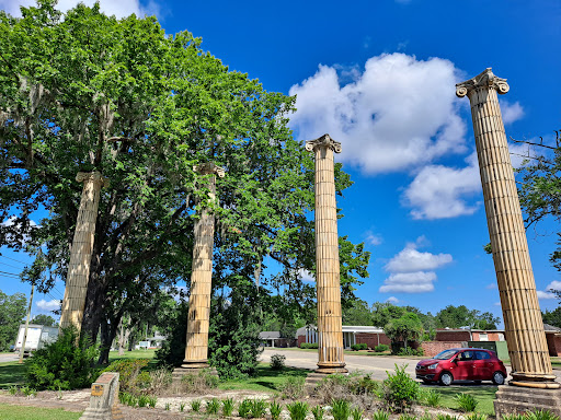 Remnants of ancient architecture, standing tall against a backdrop of blue sky and lush greenery.