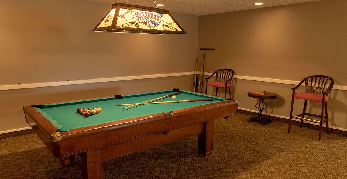 A cozy game room featuring a pool table and comfortable seating.