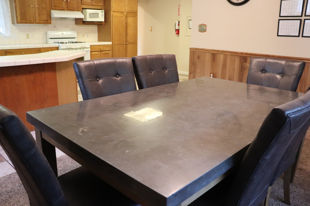 A modern dining table with chairs in a kitchen setting.