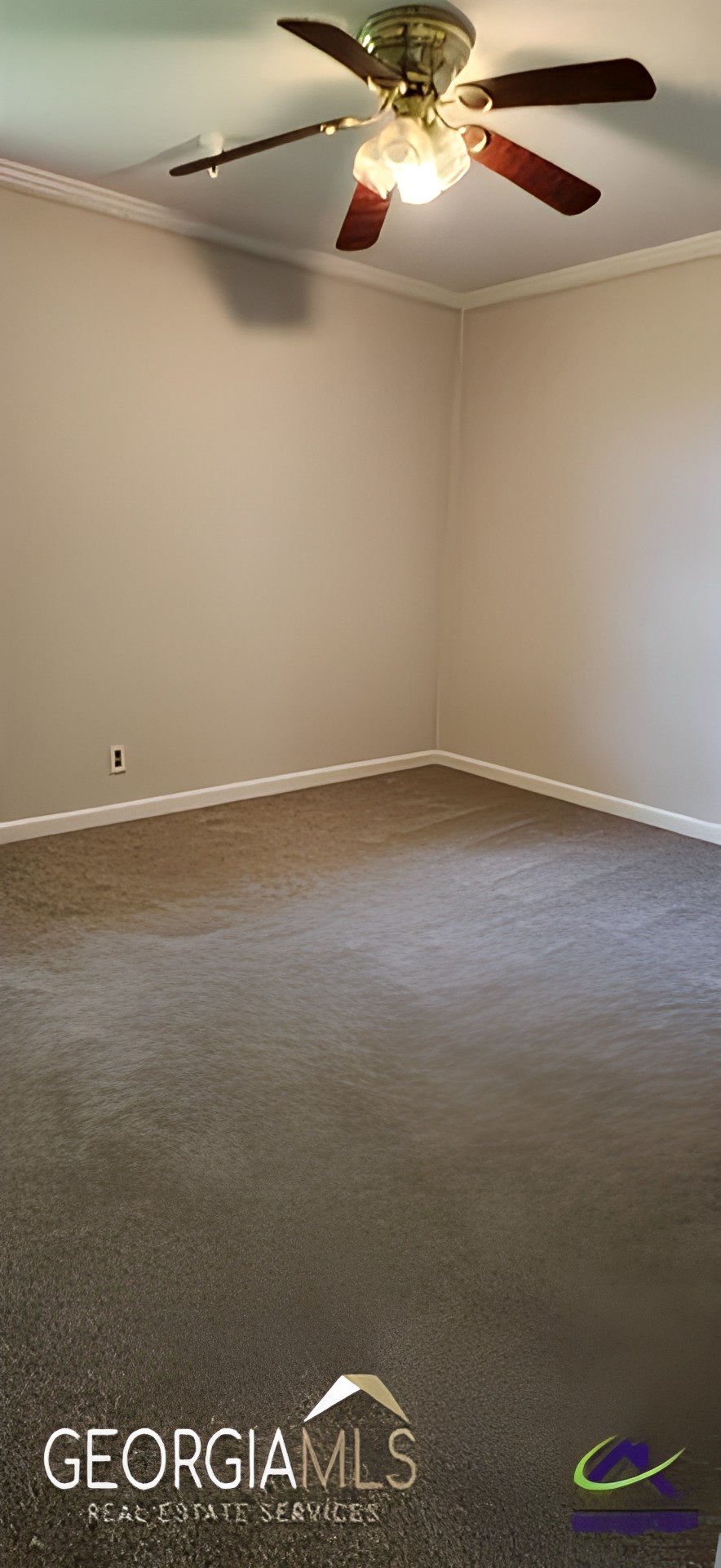 A minimalist empty room with beige walls and a carpeted floor.