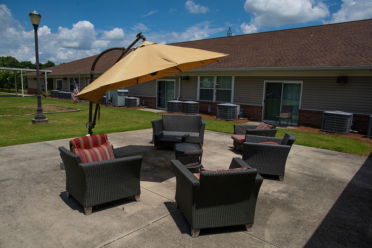 Outdoor patio setup with comfortable seating and a large umbrella.