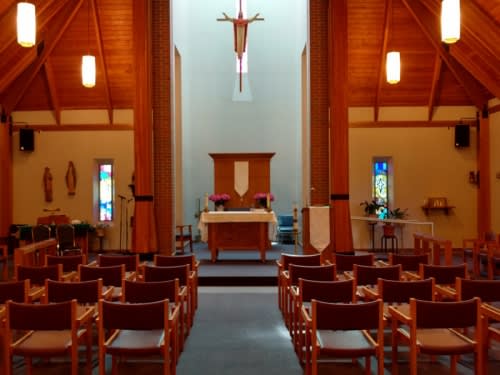 Interior view of a church with an altar and rows of pews.