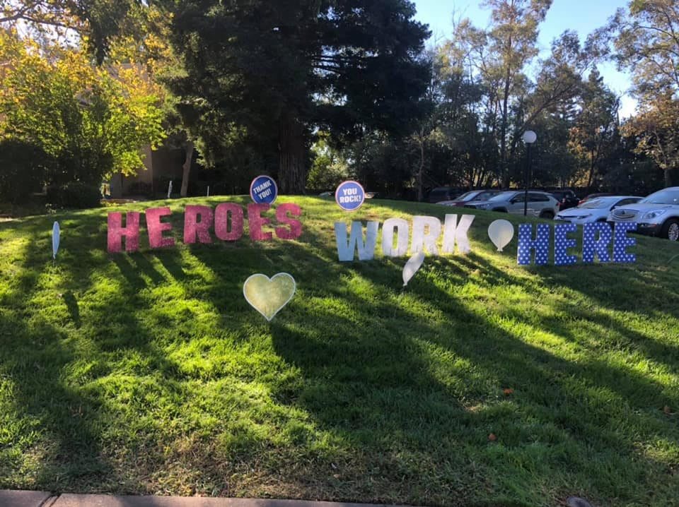 Colorful birthday signs displayed on a grassy lawn.