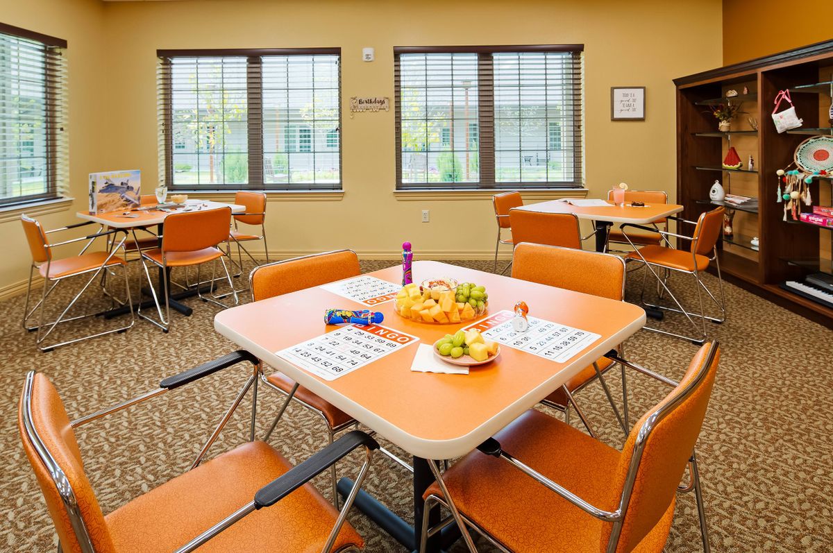 A bright dining area with tables set for a meal, featuring fruits as a centerpiece.
