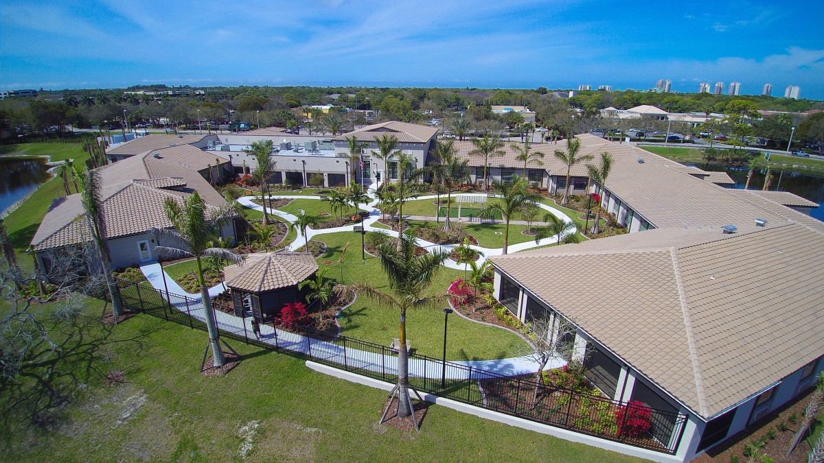 Aerial view of a residential complex with landscaped courtyards and palm trees.