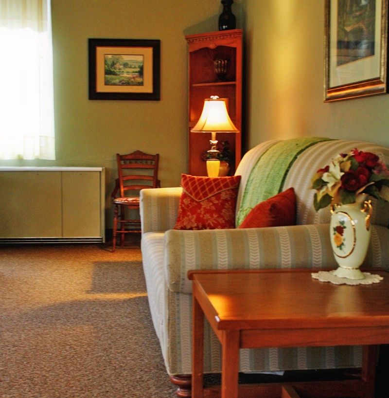 A cozy living room with a sofa, lamp, and decorative elements.