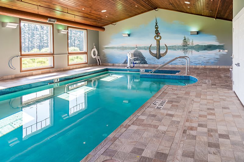 An indoor swimming pool with a nautical-themed mural featuring an anchor.