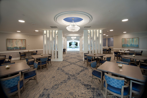 A modern dining area featuring elegant lighting and spacious seating arrangements.