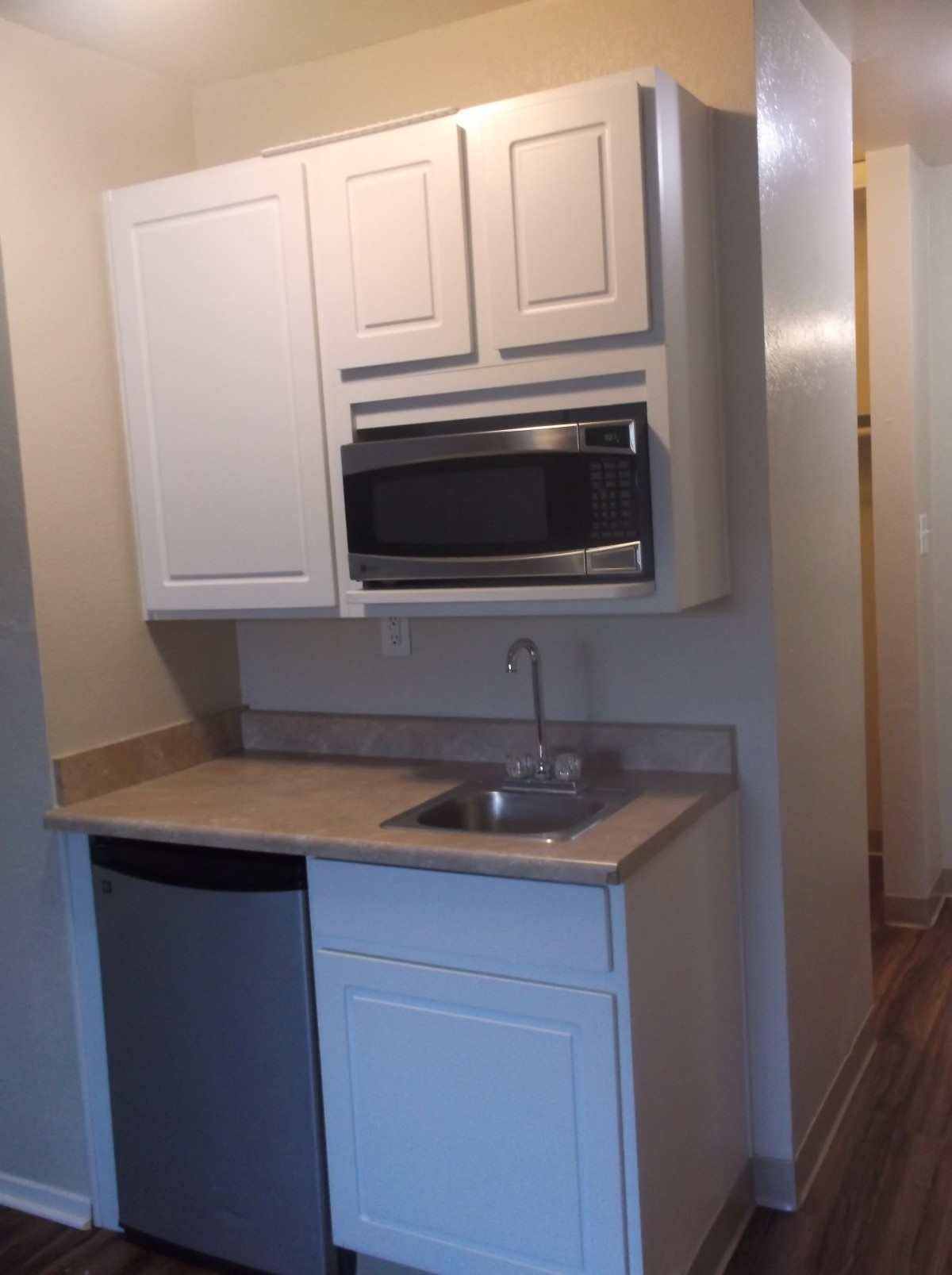 A compact kitchenette featuring a microwave and small sink area.