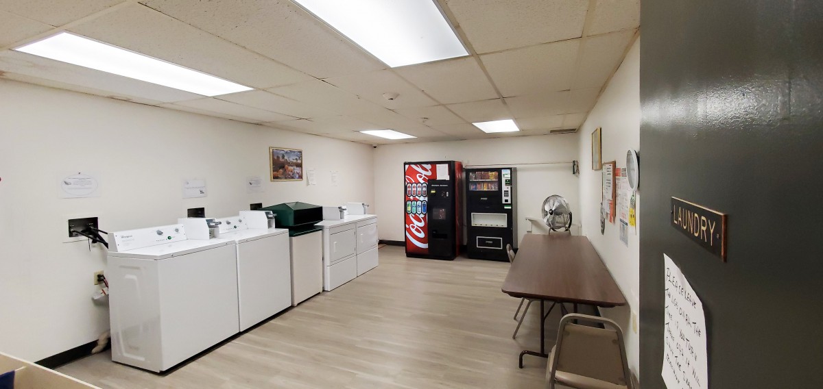 A clean laundry room with washing machines and vending machines.