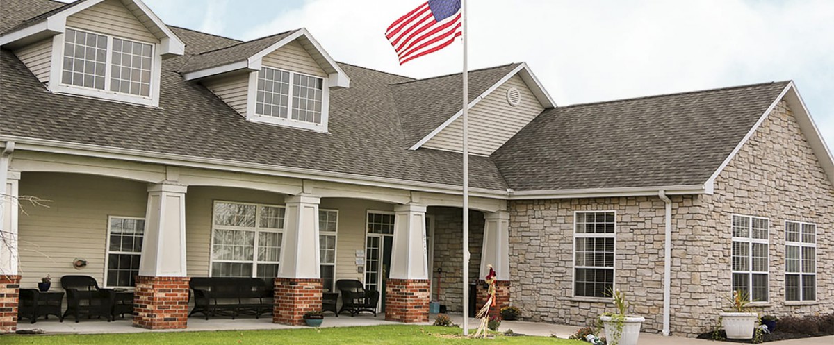 A suburban house with an American flag flying in front.