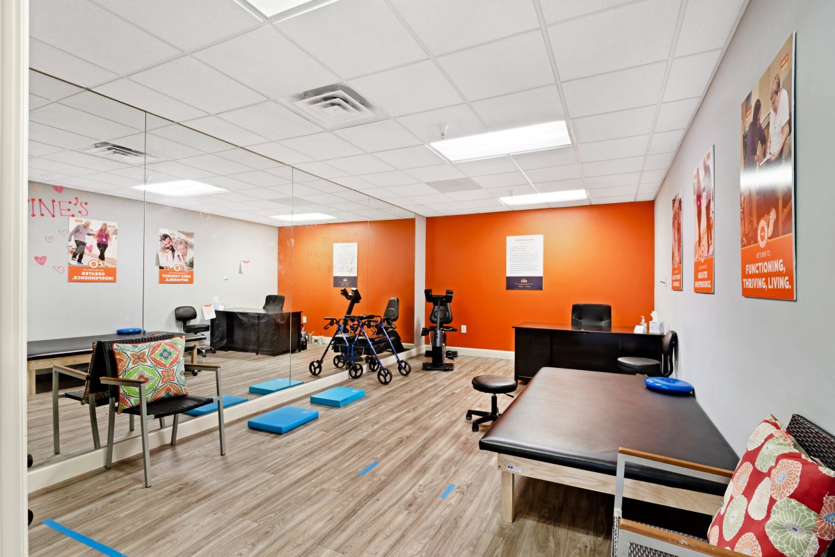 A modern physical therapy office equipped with exercise gear and treatment tables.