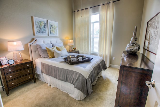 A cozy bedroom with elegant decor, featuring a comfortable bed and soft lighting.
