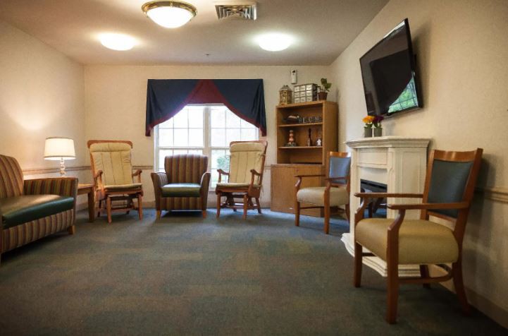 A cozy living room with comfortable seating, a fireplace, and a television.