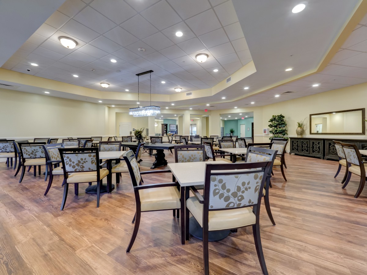 A spacious dining area with neatly arranged tables and chairs, featuring modern lighting and interior design.