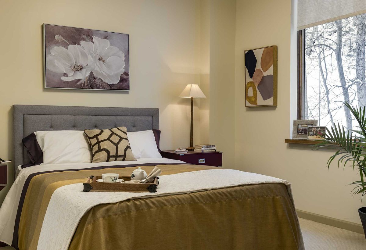 A cozy and well-decorated bedroom with stylish artwork and a neatly arranged bed.