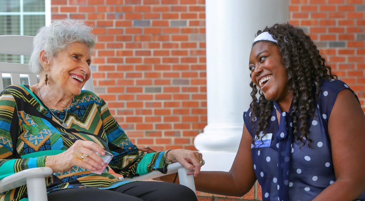Two people engaged in a pleasant conversation, sharing a moment of connection outdoors.