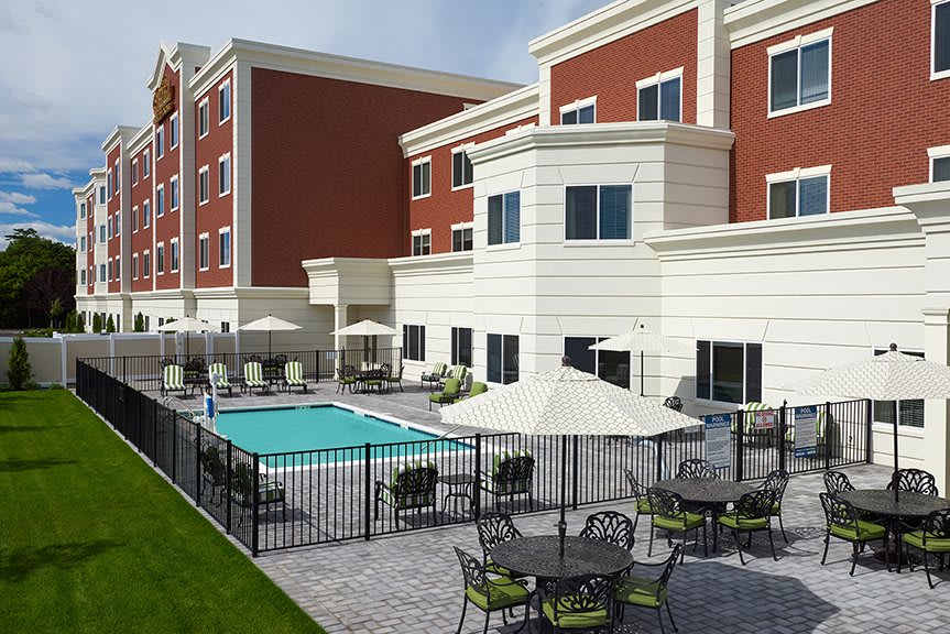 A modern hotel with an outdoor swimming pool and seating area.