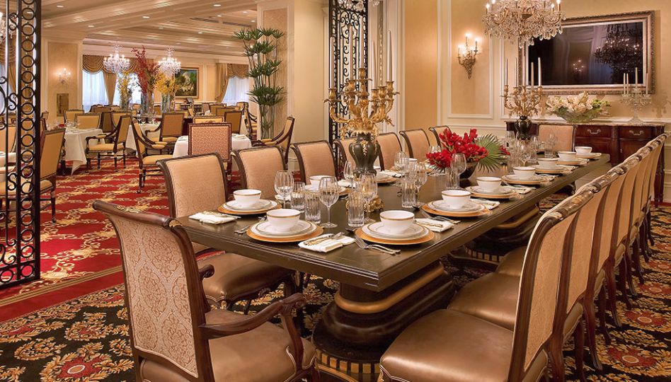 A luxurious dining room with an elegantly set table and plush seating.