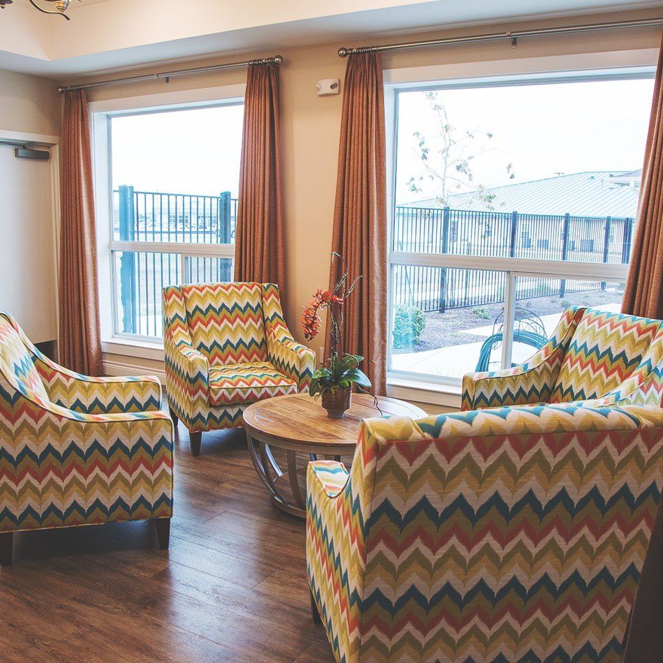 A cozy seating area with patterned armchairs and large windows letting in natural light.