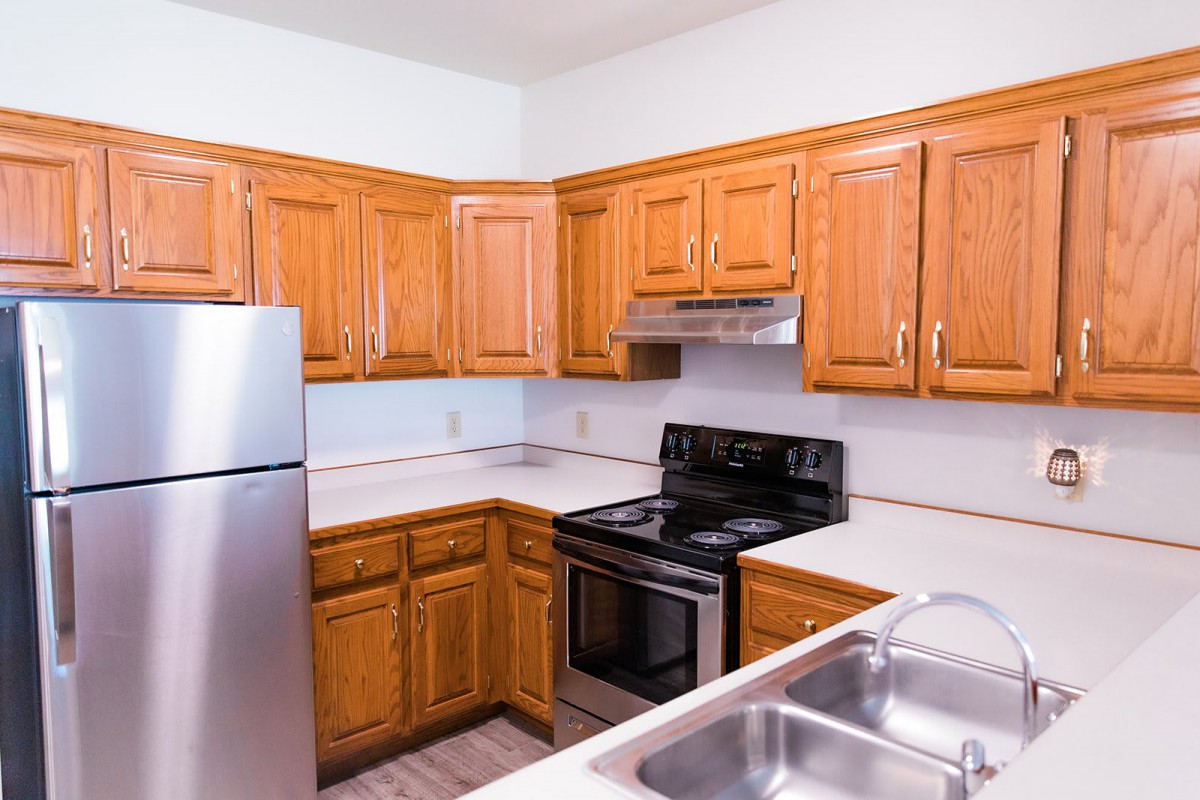 A modern kitchen with wooden cabinets and stainless steel appliances.