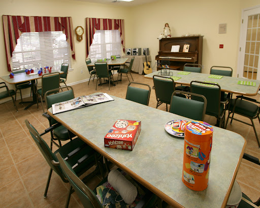 A cozy dining area featuring tables and chairs, a piano in the background, and snacks on display.