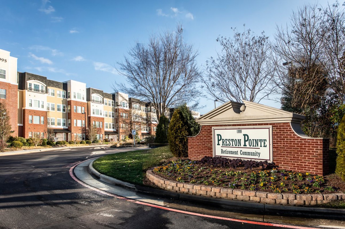 Entrance to a residential apartment complex with well-maintained landscaping.