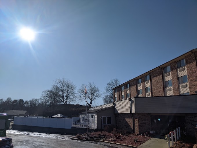 A sunny day with clear blue skies over a building next to a parking lot.