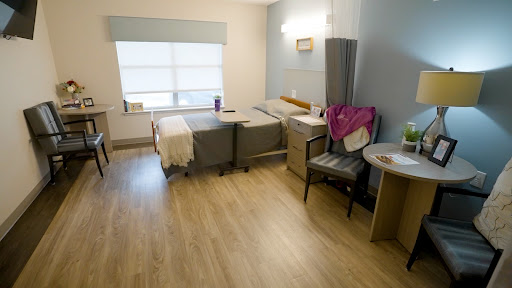 A clean and minimalist hospital patient room with two beds and natural light.