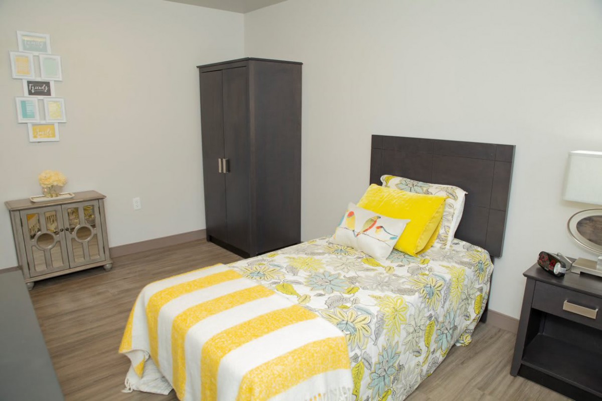 A simple bedroom with a single bed and a wardrobe.