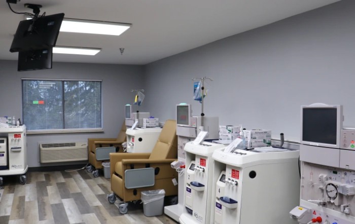 A medical treatment room with comfortable chairs and advanced equipment.