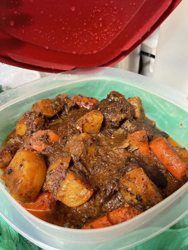 A hearty homemade beef stew with carrots and potatoes in a container.