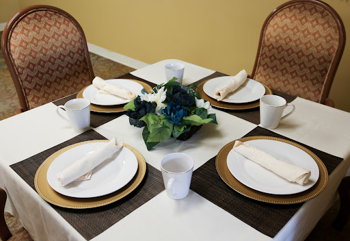A beautifully set dining table with plates, cups, and a floral centerpiece.