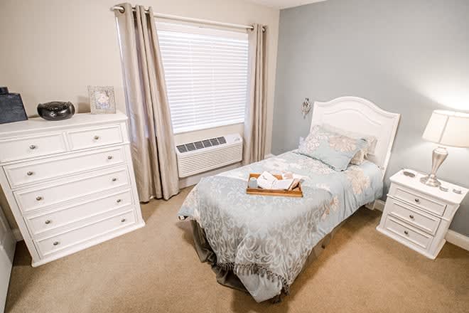 A cozy bedroom with a single bed and soft color scheme.