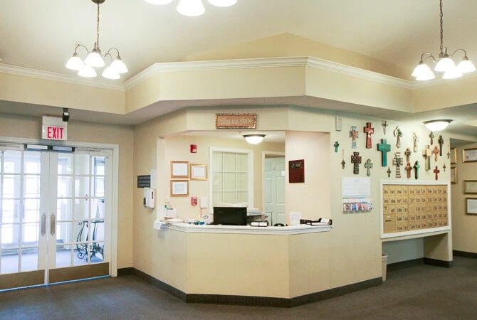 A reception area with a desk, decorated walls, and overhead lighting.