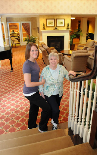 A young woman and an elderly lady posing together in a cozy indoor setting.