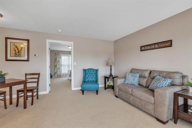 A cozy living room with a sofa, armchair, and elegant decor.