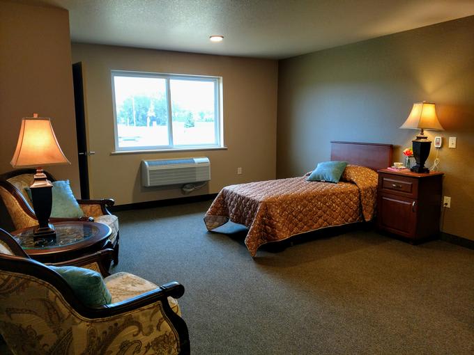 A cozy bedroom featuring a single bed, a window, and classic furniture.