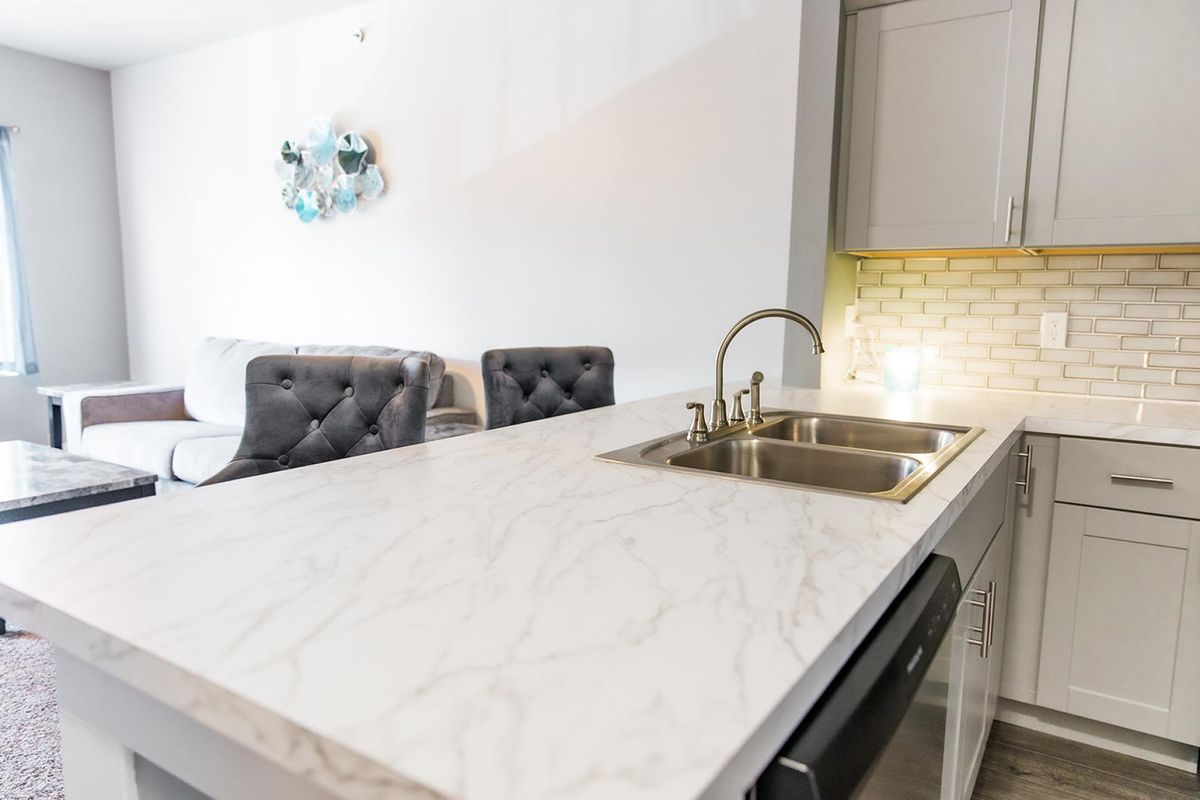 Modern kitchen with a marble countertop and sink.