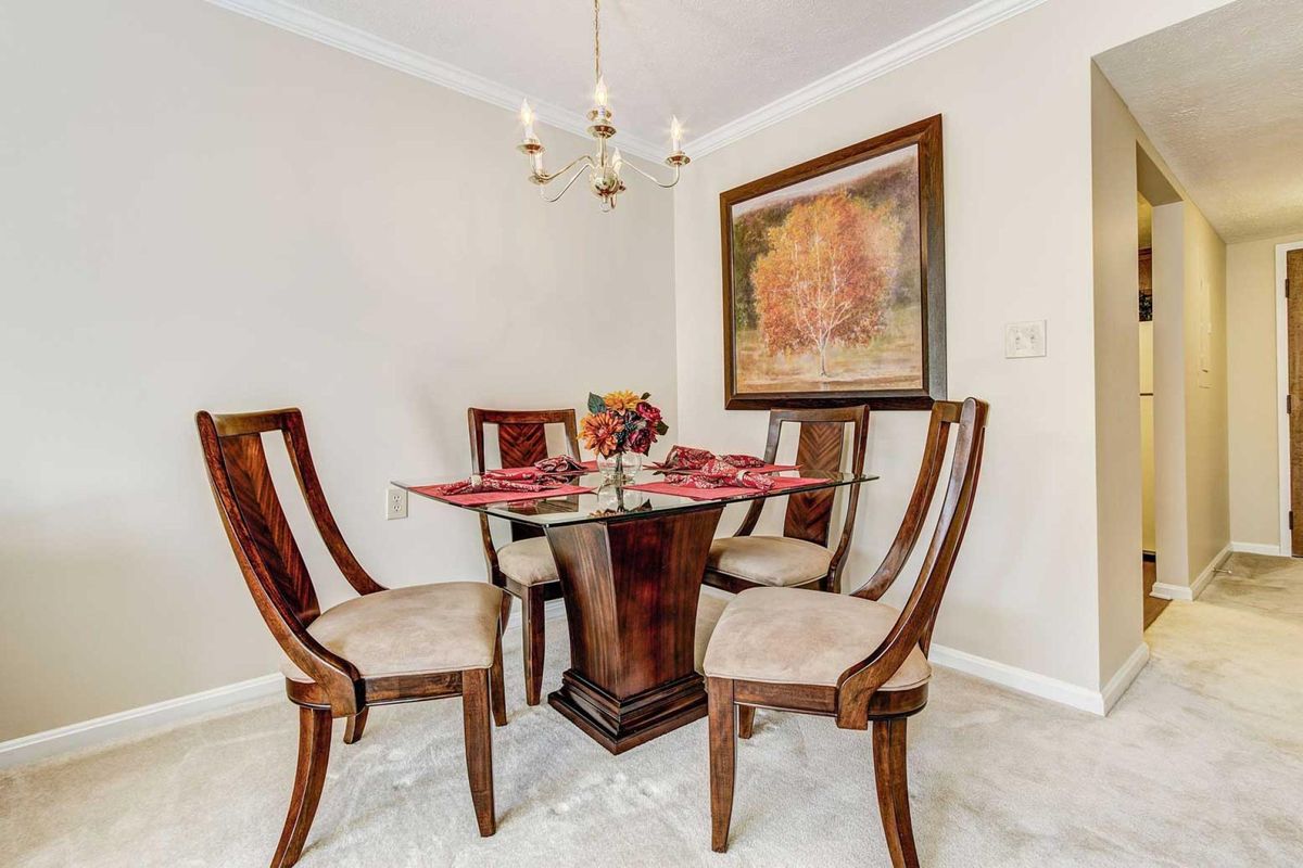 A cozy dining area with elegant wooden furniture and a decorative painting on the wall.