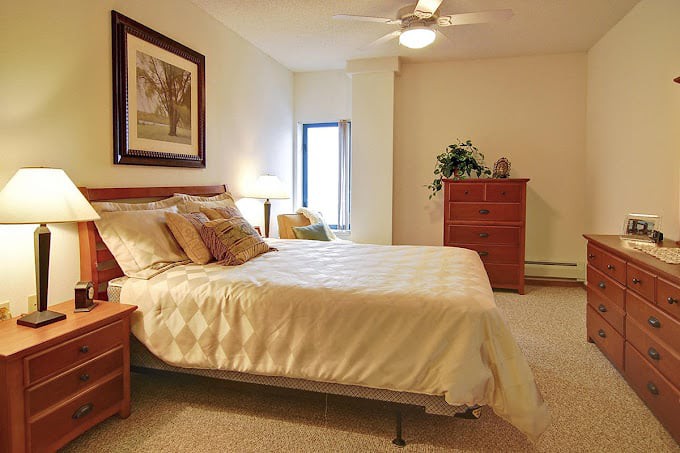A cozy bedroom featuring a comfortable bed, elegant decor, and warm lighting.