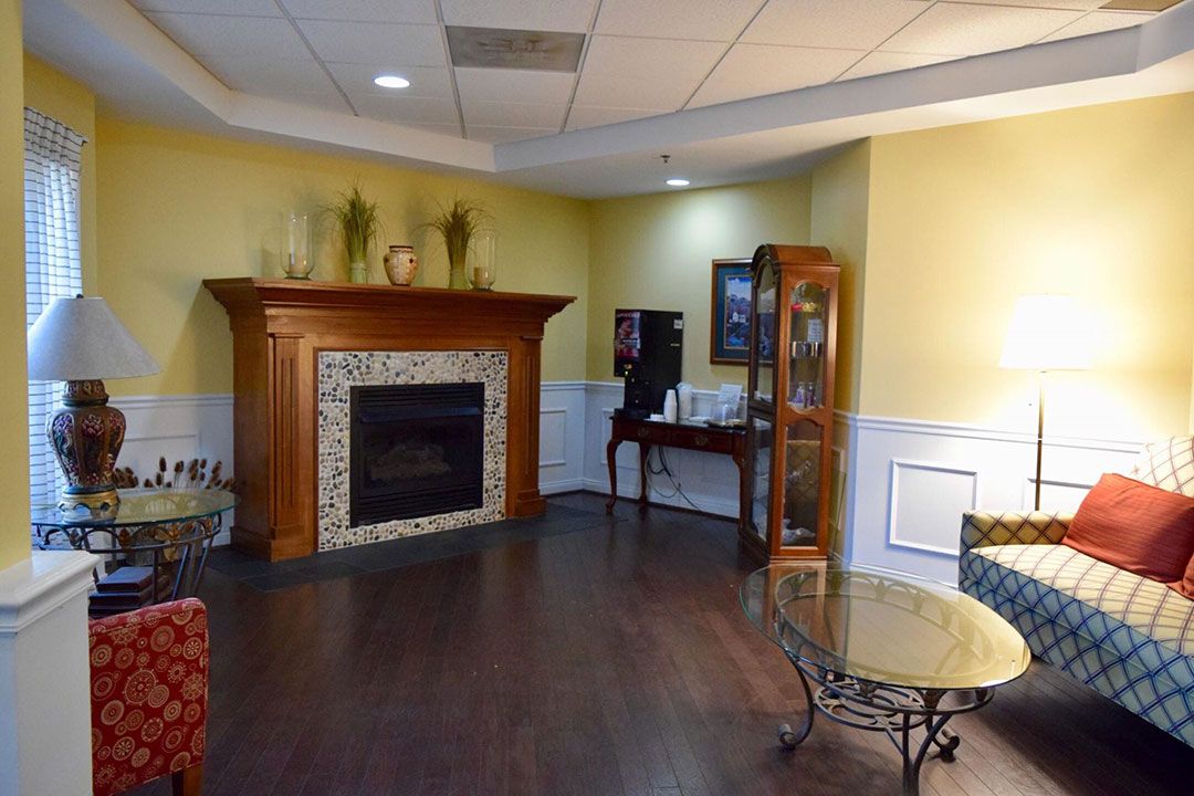 A cozy indoor living area featuring a fireplace, wood flooring, and furniture.