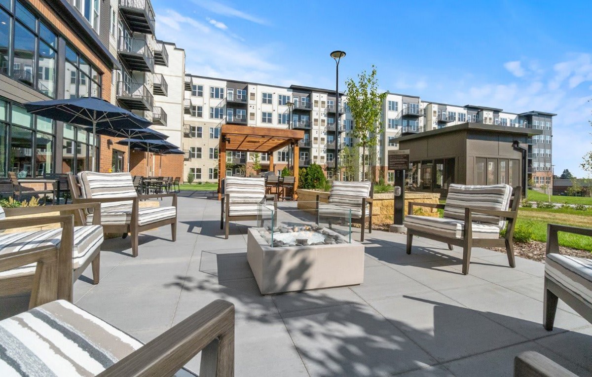 Modern apartment complex with outdoor seating and a fire pit area.