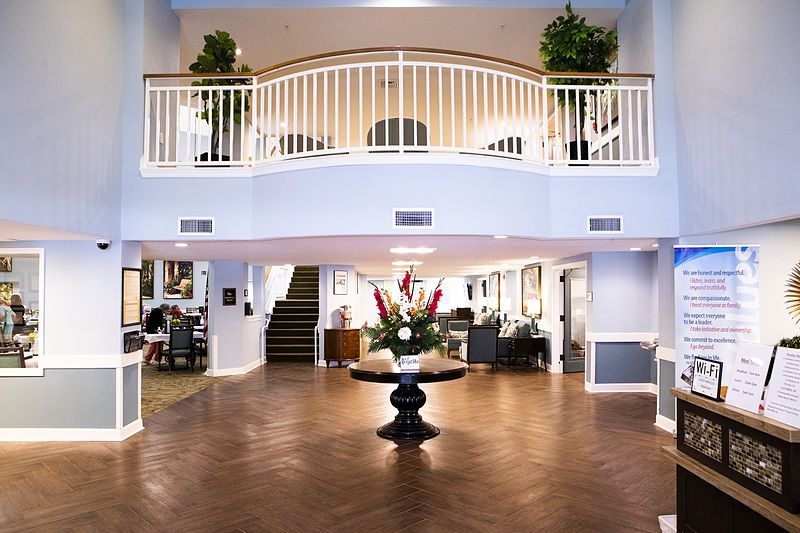 A spacious hotel lobby with elegant decor and a central staircase.