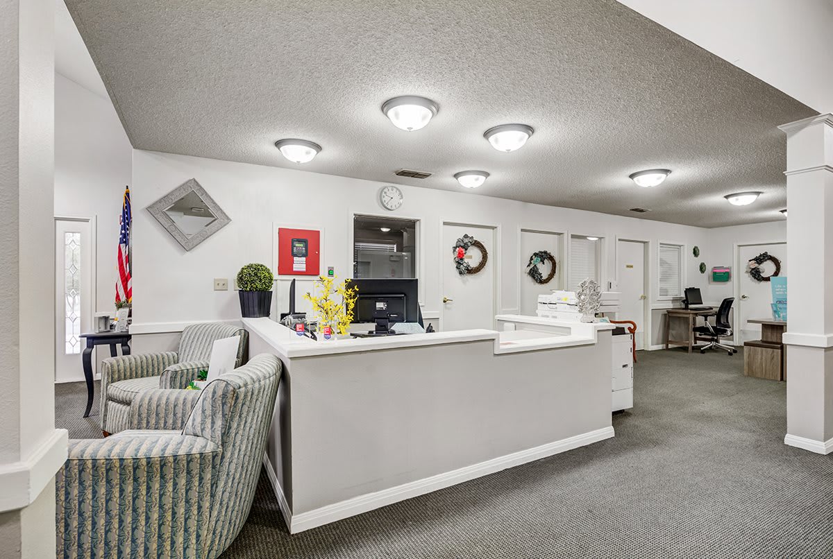 A well-lit reception area with a central desk and comfortable seating.