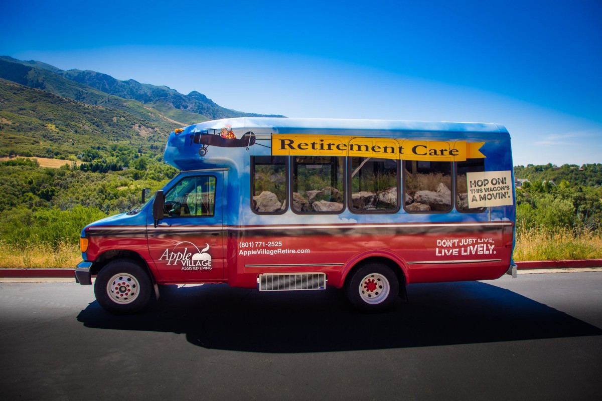 A colorful 'Retirement Cart' bus parked against a scenic mountain backdrop.