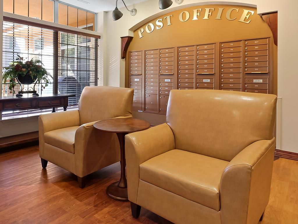 Comfortable seating in a post office lobby with mailboxes.
